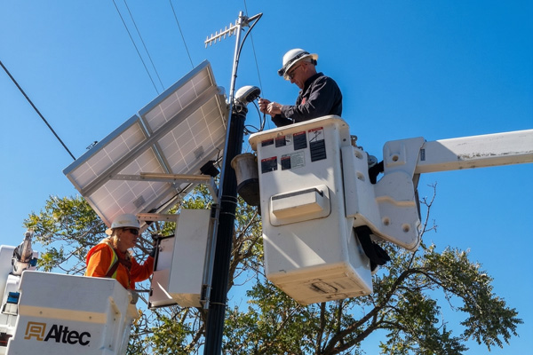 Field technician installing MAPPS pole mount solar system from bucket truck
